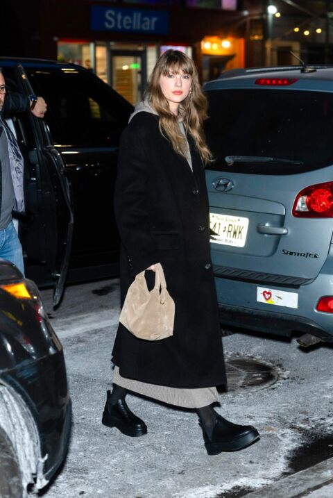 Taylor Swift associe son long manteau noir avec une robe pull à capuche The Row
