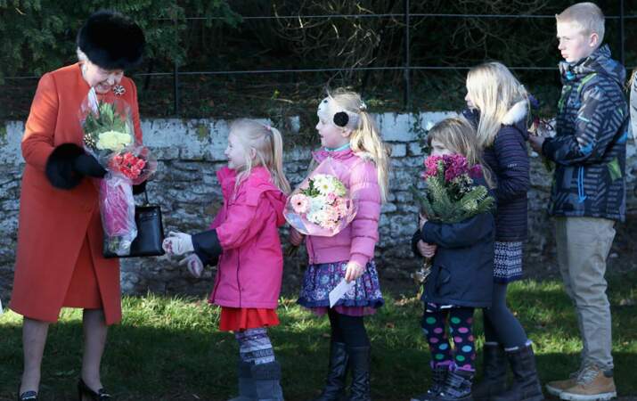 La Reine reçoit des fleurs des enfants du coin