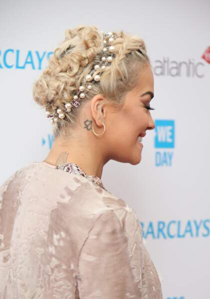 Rita Ora et sa flèche tatouée derrière l’oreille, prête à être tirée par l’arc de Cupidon.