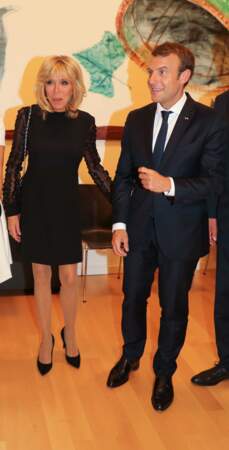 Pour l'occasion, Brigitte Macron porte une courte robe noire avec de longues manches en dentelle