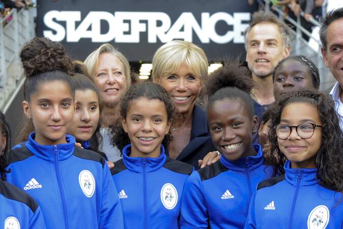 Brigitte Macron très contente de prendre la pose avec les jeunes filles du club de Saint-Denis