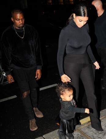 Petite jupe en cuir noir et grosses boots, North est bien assortie à la tenue de ses parents.