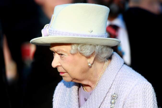La reine Elizabeth dans un ensemble parme et gants noirs