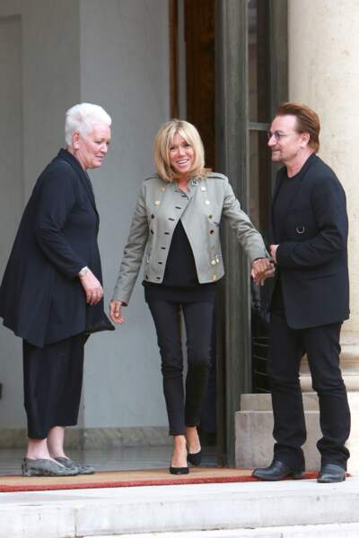 Brigitte Macron est très chic en slim noir, pull noir et veste d'inspiration militaire