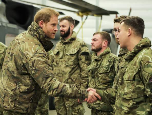 Le prince Harry souriant lorsqu'il salue des membres des Royal Marines