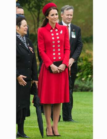 En emblème du pays qui orne son manteau robe rouge, associé à des escarpins et une pochette noirs