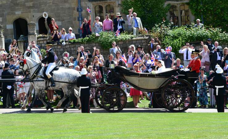 Le prince Harry et Meghan Markle saluant la foule