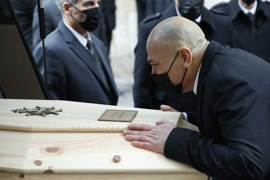 Krzysztof Leon Dziemaszkiewicz, le dernier compagnon du créateur, embrasse son cercueil à la sortie du temple, à Paris, le 4 février 2022