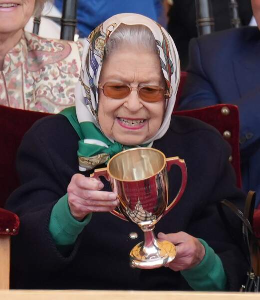 La reine Elizabeth II tout sourire en tenant son trophée à Windsor 