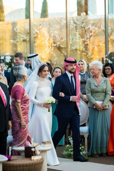 Toujours au bras de son frère, le prince héritier Hussein, la princesse Iman de Jordanie défile devant les invités lors de son mariage à Amman le 12 mars 2023