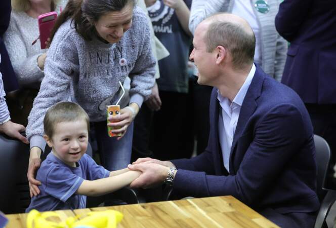 Le prince William tient la main de Tympthi, un petit garçon âgé de 4 ans, alors qu'il parle avec des résidents ukrainiens de leurs expériences de déménagement en Pologne lors d'une visite dans un centre d'hébergement à Varsovie. 