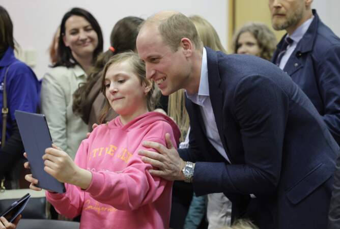 Le prince de Galles pose pour des photos avec un jeune résident ukrainien.