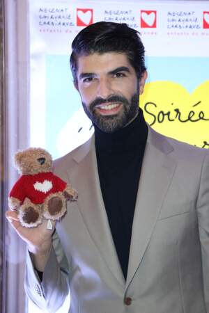 L'artiste Ruben Molina pose avec Petit Coeur, la mascotte de la soirée au gala de bienfaisance à la Salle Gaveau de l'association Mécénat Chirurgie Cardiaque le 27 mars 2023 à Paris.