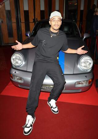 Il pose devant une des voitures présentes dans le film