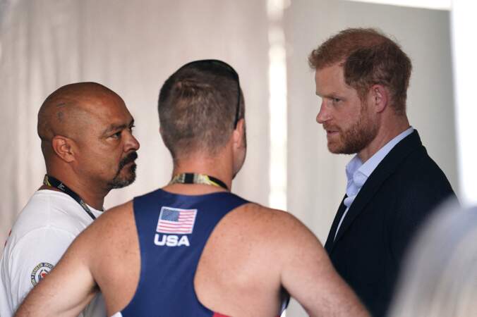 Il discute avec un membre de l'équipe des États-Unis dans une tente à côté de la piste d'athlétisme pendant les finales d'athlétisme