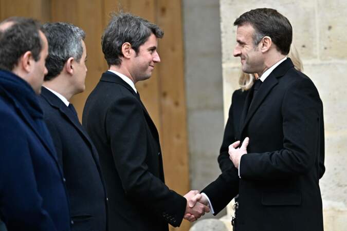 Emmanuel Macron en profite pour saluer certains membres du gouvernement, ici Gabriel Attal, le premier ministre