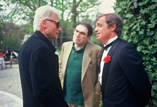 Jean-Paul Belmondo (53 ans) entouré de Johnny Hallyday et Robert Hossein pour le mariage de sa fille Patricia en 1986