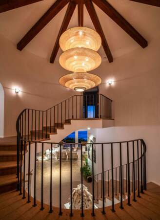 L'escalier de la maison est atypique et mène à une suite parentale avec cheminée, coin salon, salle de bains et dressing