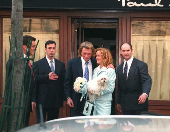 Johnny Hallyday et sa femme Laeticia devant un restaurant à Paris aux côtés de Jean-Claude Camus le jour de leur mariage, le 25 mars 1996. 