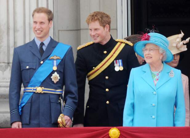 Durant la traditionnelle parade militaire Trooping the Colour organisée en juin, ici de l'année 2008, William et Harry posent aux côtés de leur grand-mère. Ils ne peuvent se retenir de rire des petits commentaires qu'ils se font