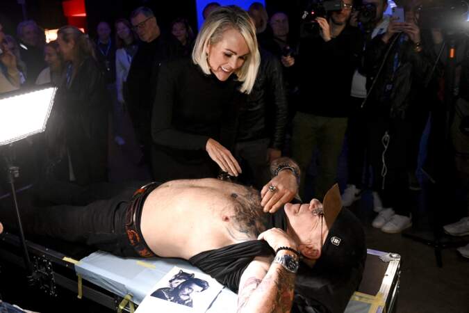 Laeticia Hallyday regarde le tatouage à l'effigie du chanteur sur le torse de l'un des fans