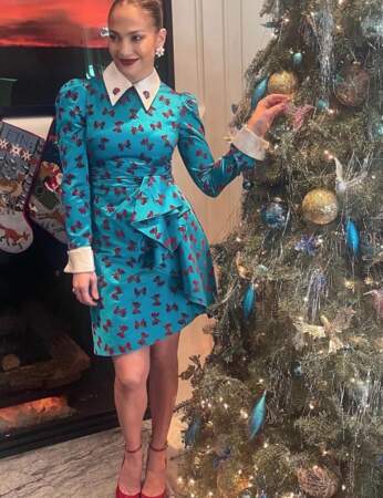 Jennifer Lopez arbore une robe bleu avec des motifs en forme de noeuds de Noël. 
