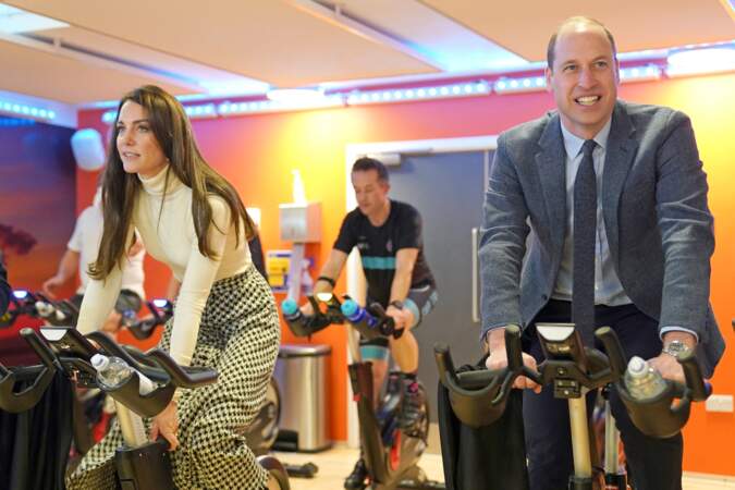Le prince et la princesse de Galles commencent une course de vélos elliptiques lors de leur visite d'un centre de fitness à Port Talbot, au Pays de Galles, le 28 février 2023
