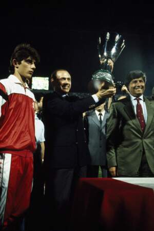 Silvio Berlusconi fait partie des hommes d'affaires les plus riches au monde. Il est la sixième plus grande fortune italienne. 
Sur cette photo prise en 1988, il porte la Supercoupe de la Ligue, remportée par Milan.