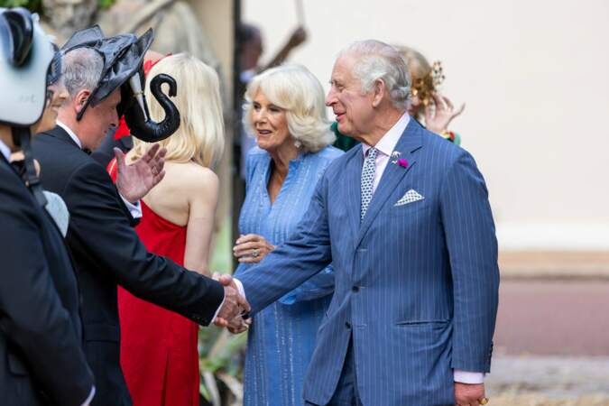 Le roi Charles III et la reine consort Camilla Parker Bowles saluent les autres invités masqués.