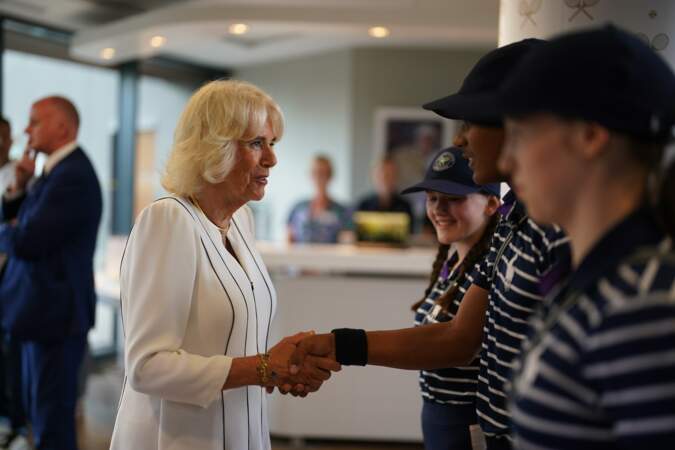 Camilla Parker Bowles discute avec des ramasseuses et ramasseurs de balles au tournoi de Wimbledon le 12 juillet 2023.