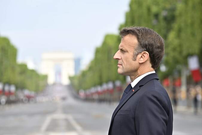 Emmanuel Macron devant la foule sur l'avenue des Champs-Élysées.