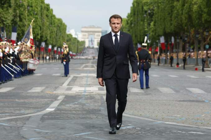 Emmanuel Macron marche sur l'avenue des Champs-Élysées.