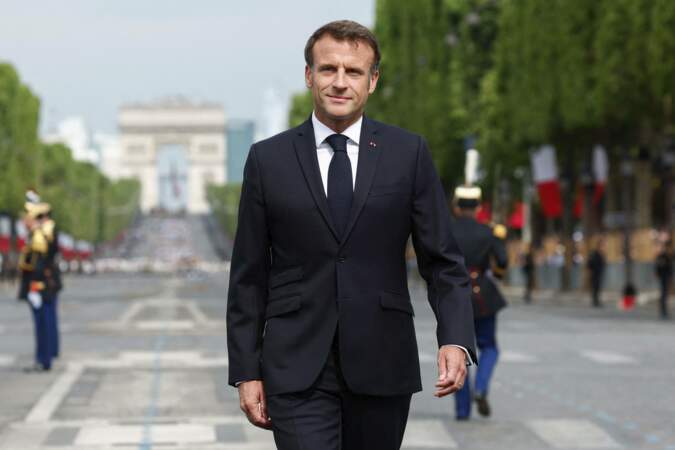 Emmanuel Macron marche sur l'avenue des Champs-Élysées.