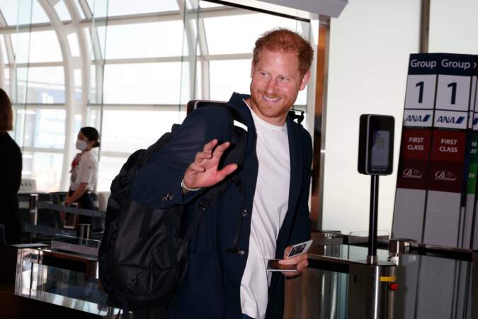Il a salué les photographes et les gens présents dans l'aéroport.
