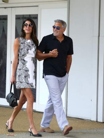 Amal Clooney porte une petite robe légère noire et blanche avec des petits escarpins.