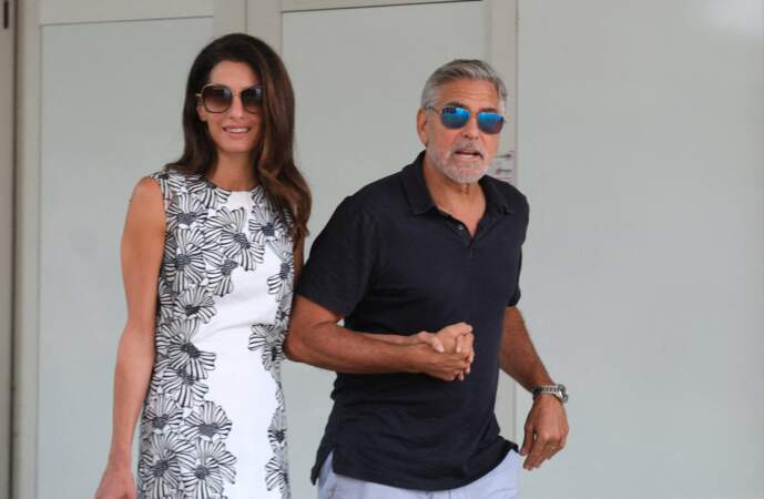 George Clooney marche d'un pas décidé pour rejoindre le petit bateau qui les attend.