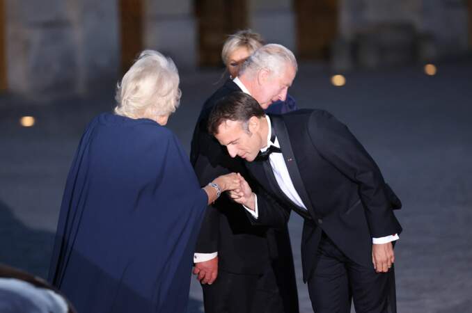 Emmanuel Macron effectue un baisemain à la reine Camilla.