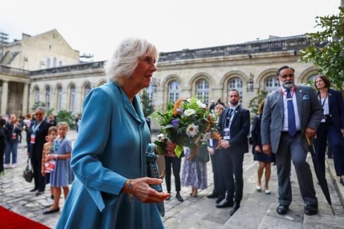 La reine Camilla s'apprête à rentrer dans la mairie de Bordeaux avec un bouquet à la main