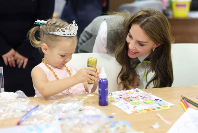La princesse de Galles aide une jeune fille lors d'une séance d'art et d'artisanat au cours d'une visite au centre communautaire Vsi Razom.
