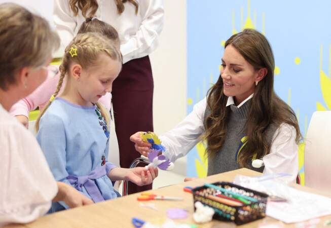 La princesse de Galles aide une jeune fille lors d'une séance d'art et d'artisanat au cours d'une visite au centre communautaire Vsi Razom.