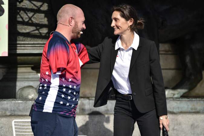 L'archer américain Matthew Stutzman rencontre la ministre française des Sports Amélie Oudea-Castera devant le public lors de la Journée paralympique, à la veille du lancement de la billetterie pour les Jeux paralympiques, place de la République à Paris, France, le 8 octobre 2023.