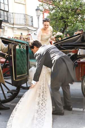 La princesse monte dans le carrosse et son mari l'aide à ranger la traine de sa robe 