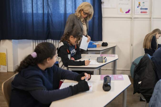 Brigitte Macron aide certains élèves à faire leur exercice