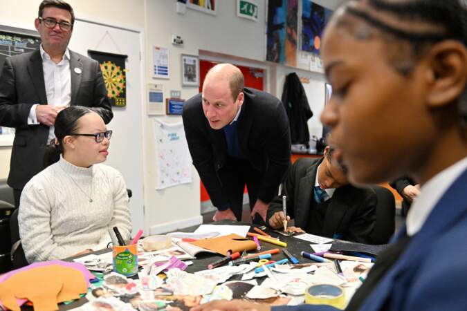 Le prince William encourage une enfant lors de sa visite officielle au Hideaway Youth Project à Manchester