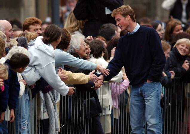 Le Prince William serre la main d'un sympathisant alors que la foule s'est rassemblée pour assister à l'arrivée du Prince à l'Université de St. Andrews.