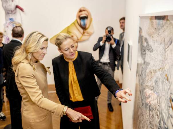 La Reine Máxima observe des photographies au coté de Viviane Sassen 