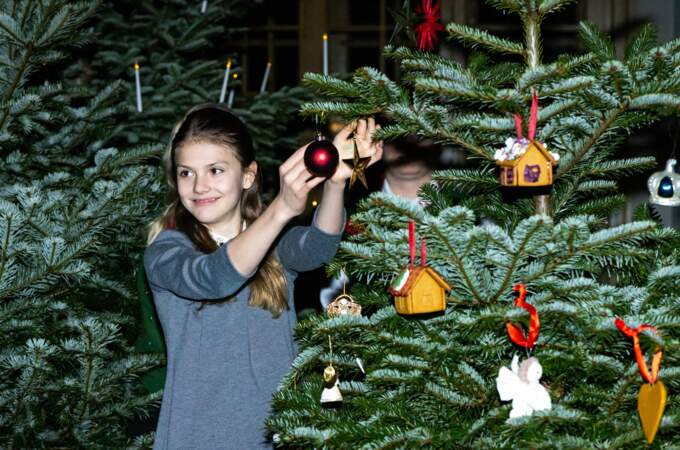 La princesse Estelle ajoute une jolie boule de Noël à l'arbre.