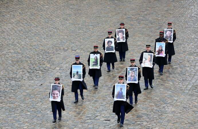 Les membres de la garde républicaine française tiennent les portraits des 42 victimes françaises