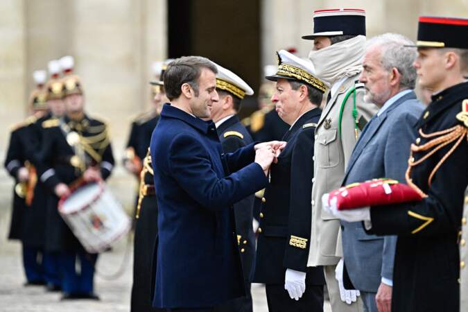 Le président Emmanuel Macron décerne la Légion d'honneur au contrôleur général des armées Denis Chevillot lors d'une cérémonie militaire de prise d'armes dans la cour de l'hôtel national des Invalides à Paris.