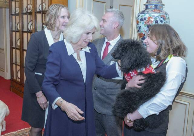 La reine Camilla est attendrie par le gros chien noir qu'on lui présente.